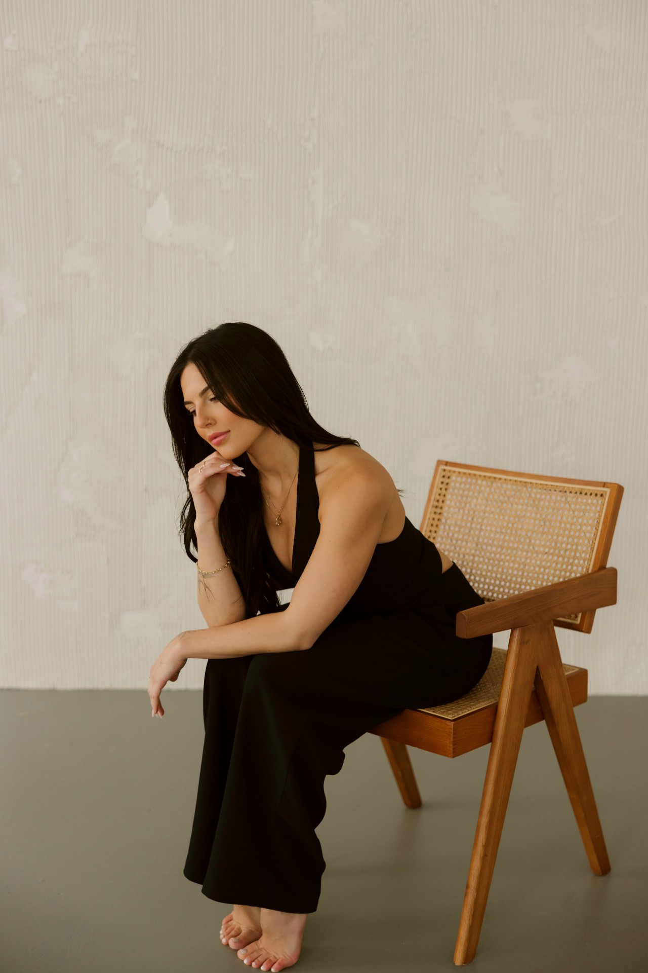 Studio KEJ founding artist seated in a cane chair