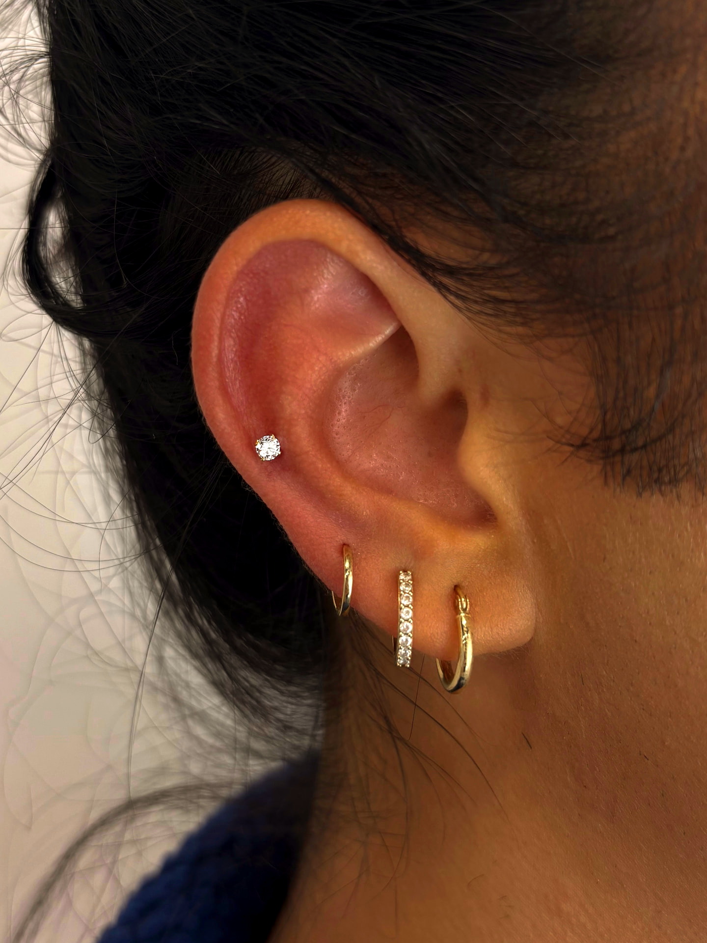 Flat piercing with gold hoop lobe stack